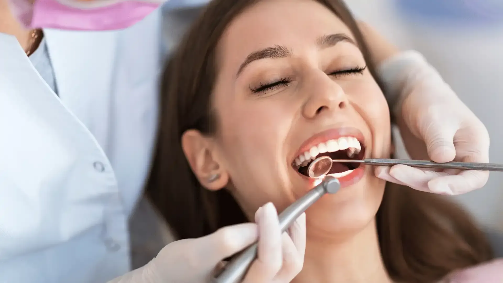 A woman is getting her teeth examined by a dentist.