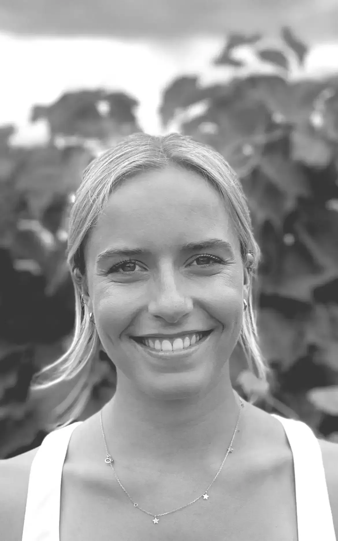 a woman is smiling in a black and white photo .