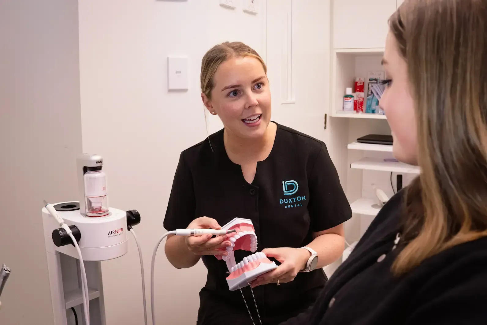 Dentist showing patient a dental model in an office setting.