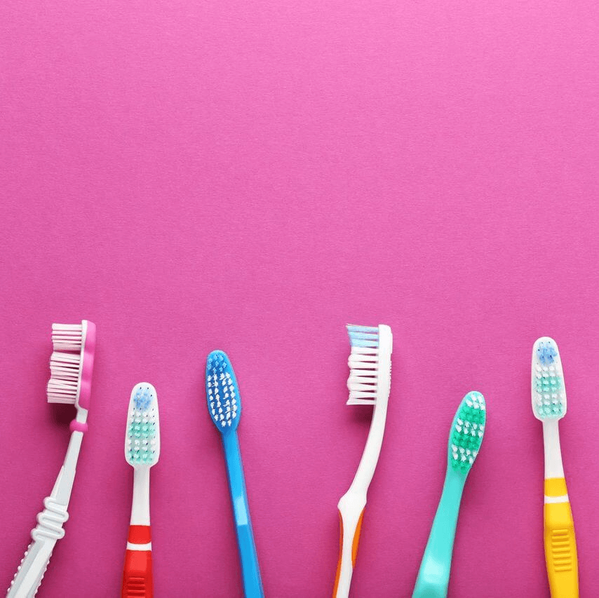toothbrushes on a pink background -hygienist Christchurch