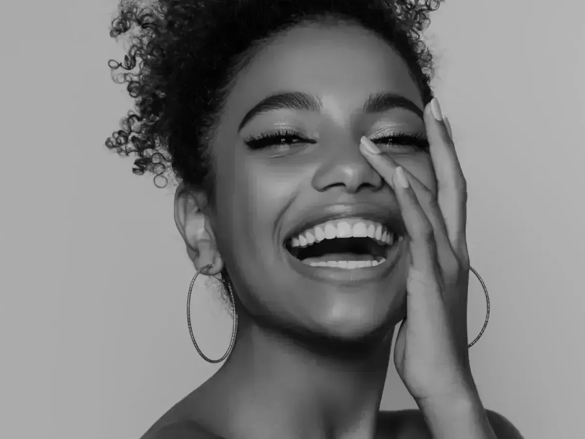 a black and white photo of a woman laughing