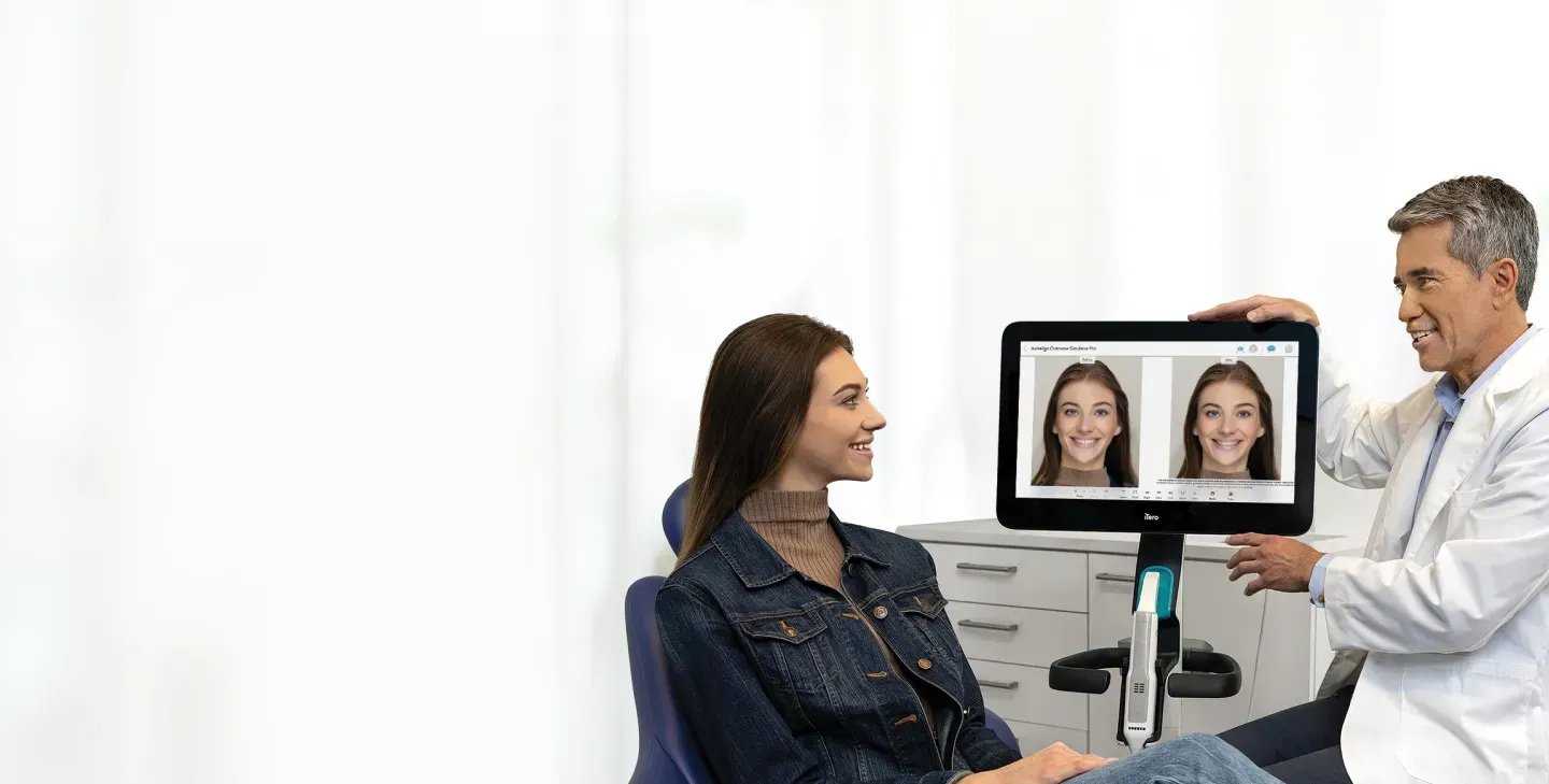 A Woman Sitting In A Chair While A Man Holds Up A Tablet