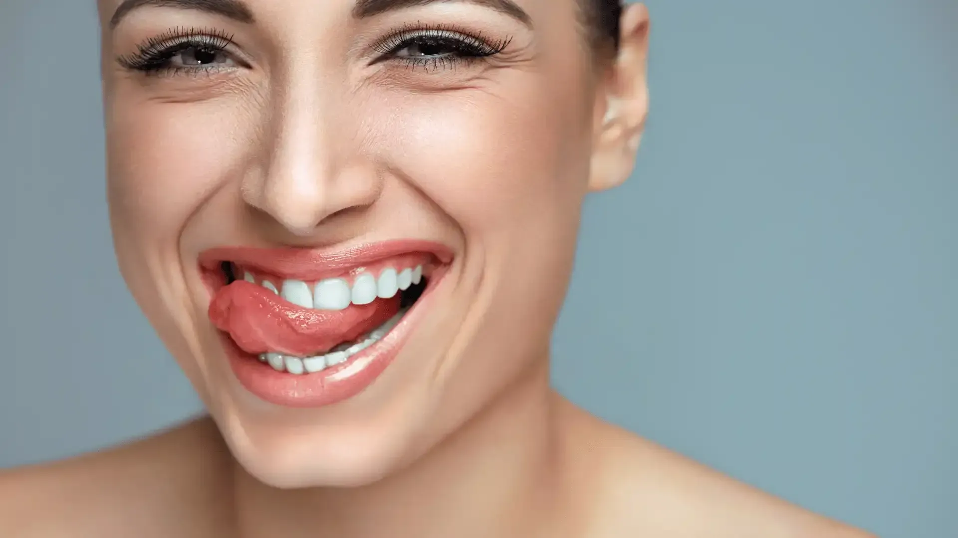 a close up of a woman 's face with her tongue sticking out .