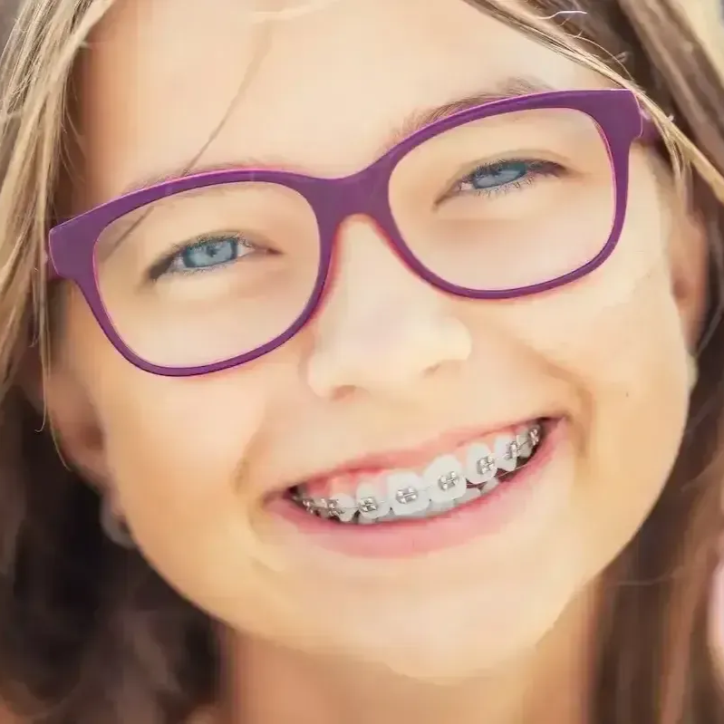 Girl with braces and purple glasses smiles.