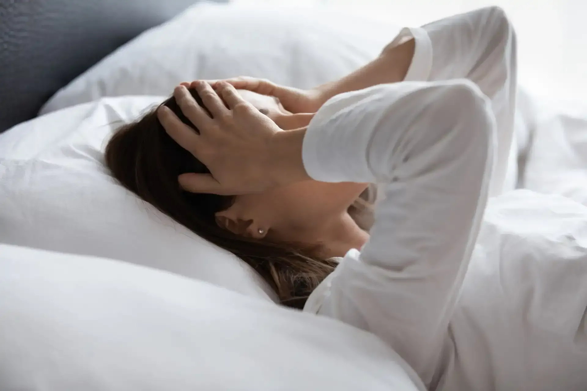 Woman in bed with Migraine