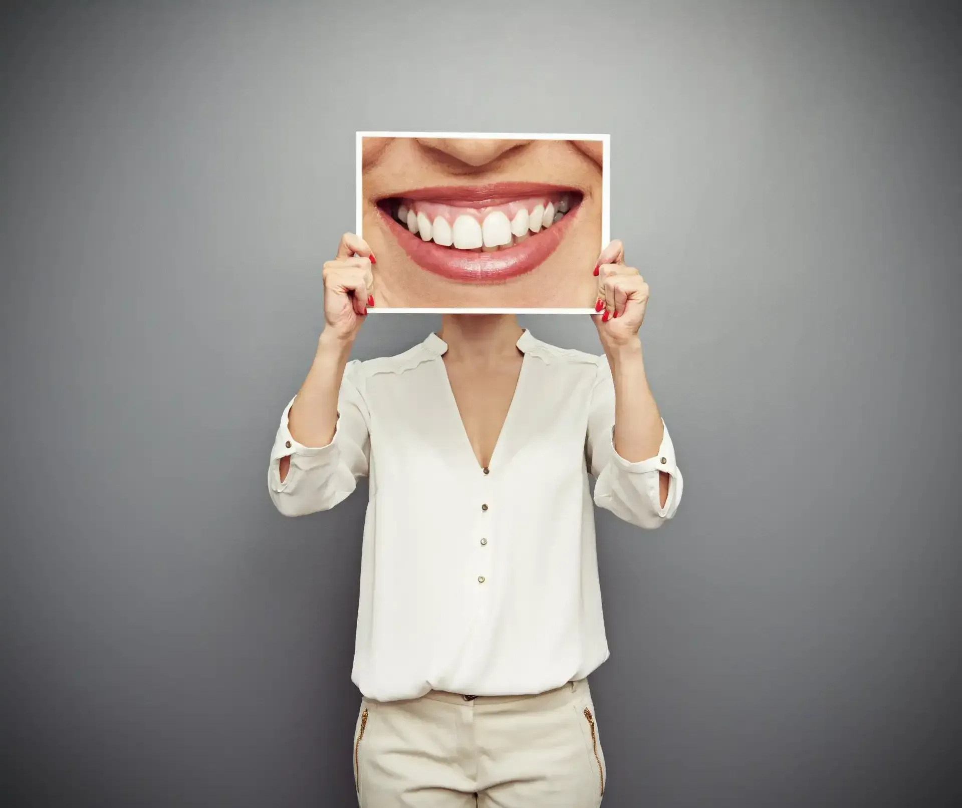 Woman holding up a picture of a bright white smile