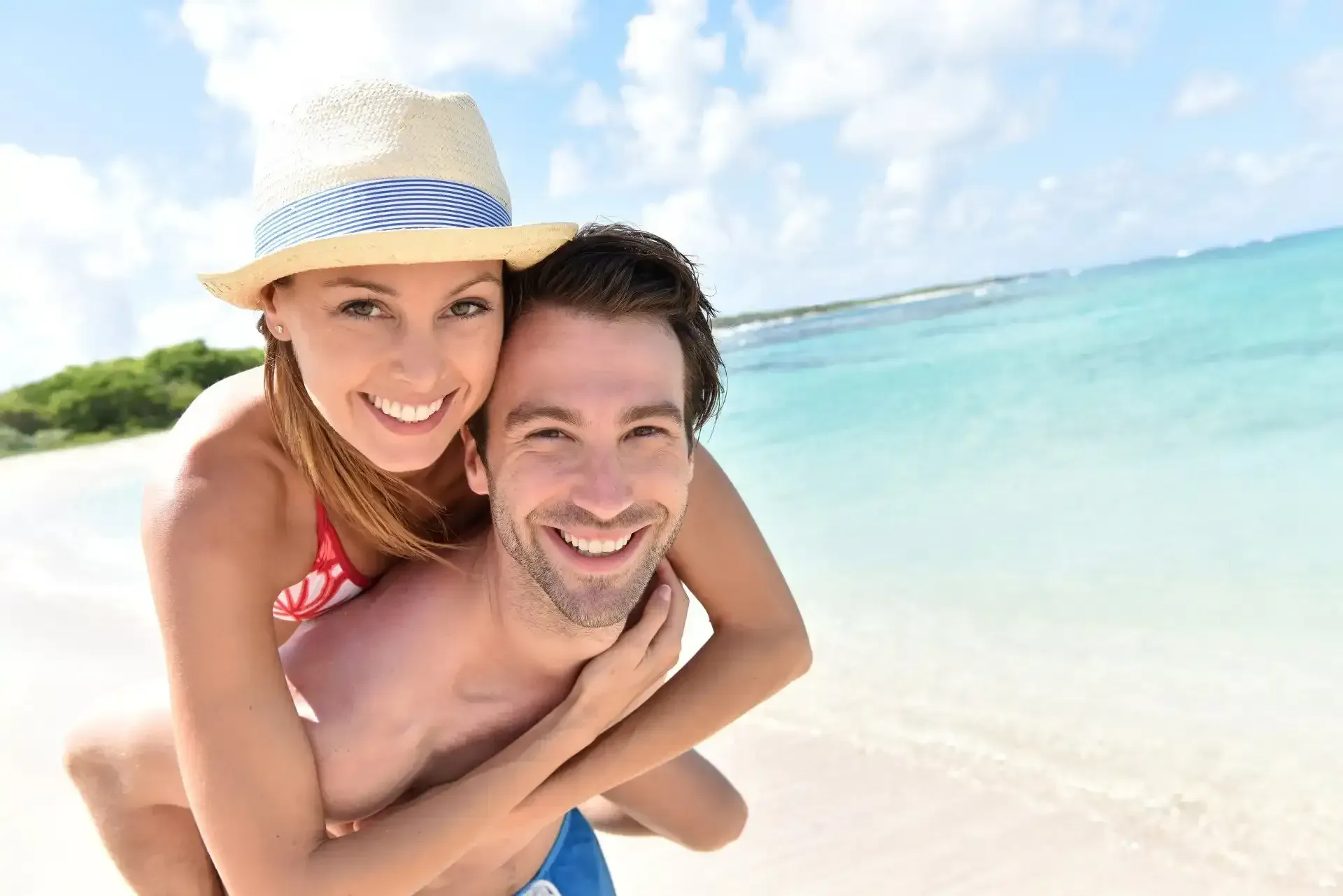 Smiling couple with nice white teeth on the beach