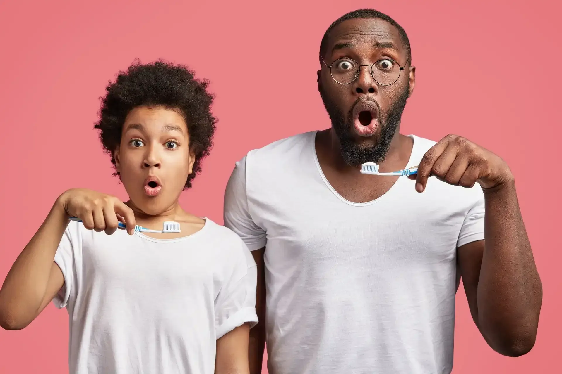 Couple with a surprised face brushing their teeth