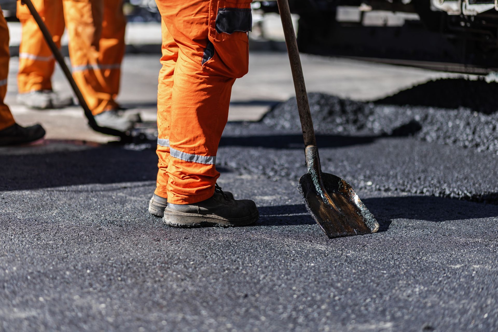 Construction workers paving a road with asphalt Construction workers paving a road with asphalt