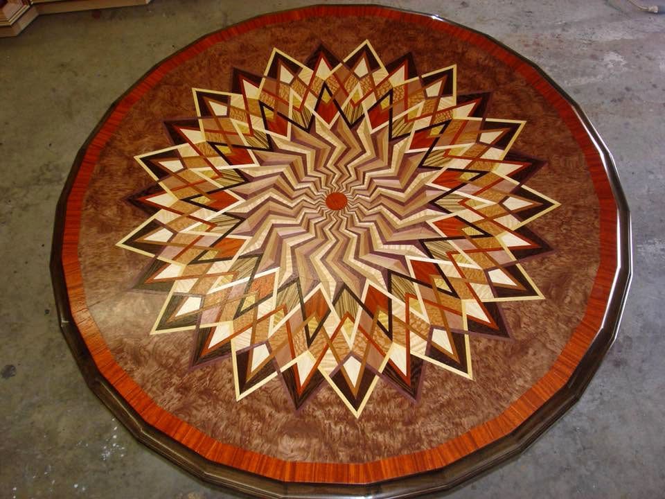 Round decorative rug with a starburst geometric pattern in brown, tan, red, and cream.