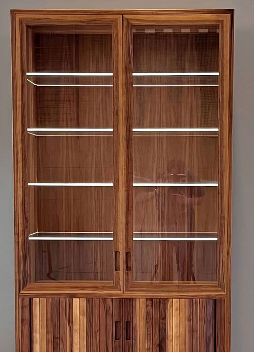 Wooden glass-front cabinet with shelves and lower storage drawers, shown against a plain wall.