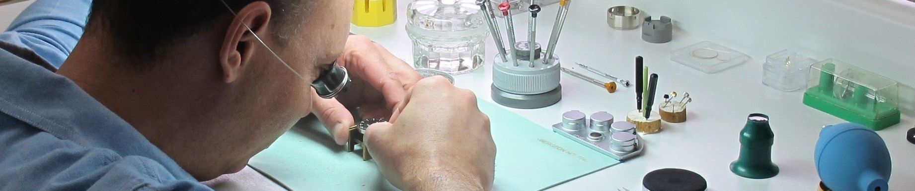Watchmaker sitting at his bench