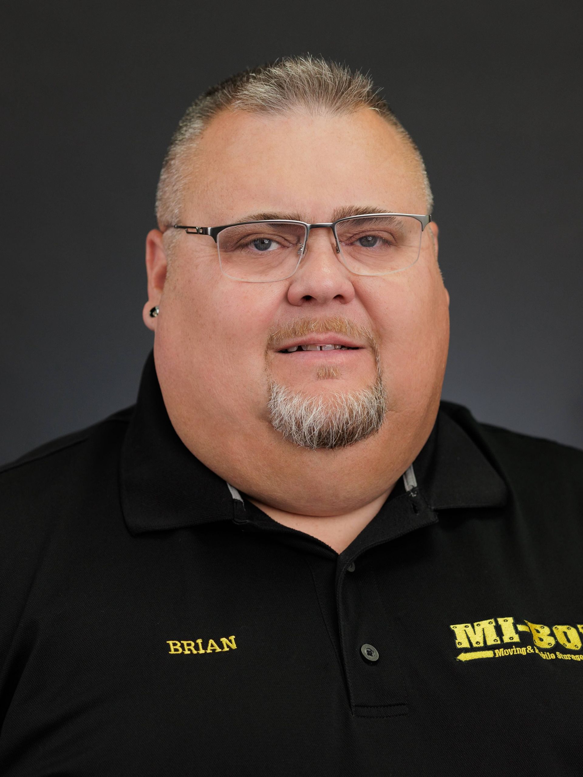 A man wearing glasses and a black shirt with the name brian on it