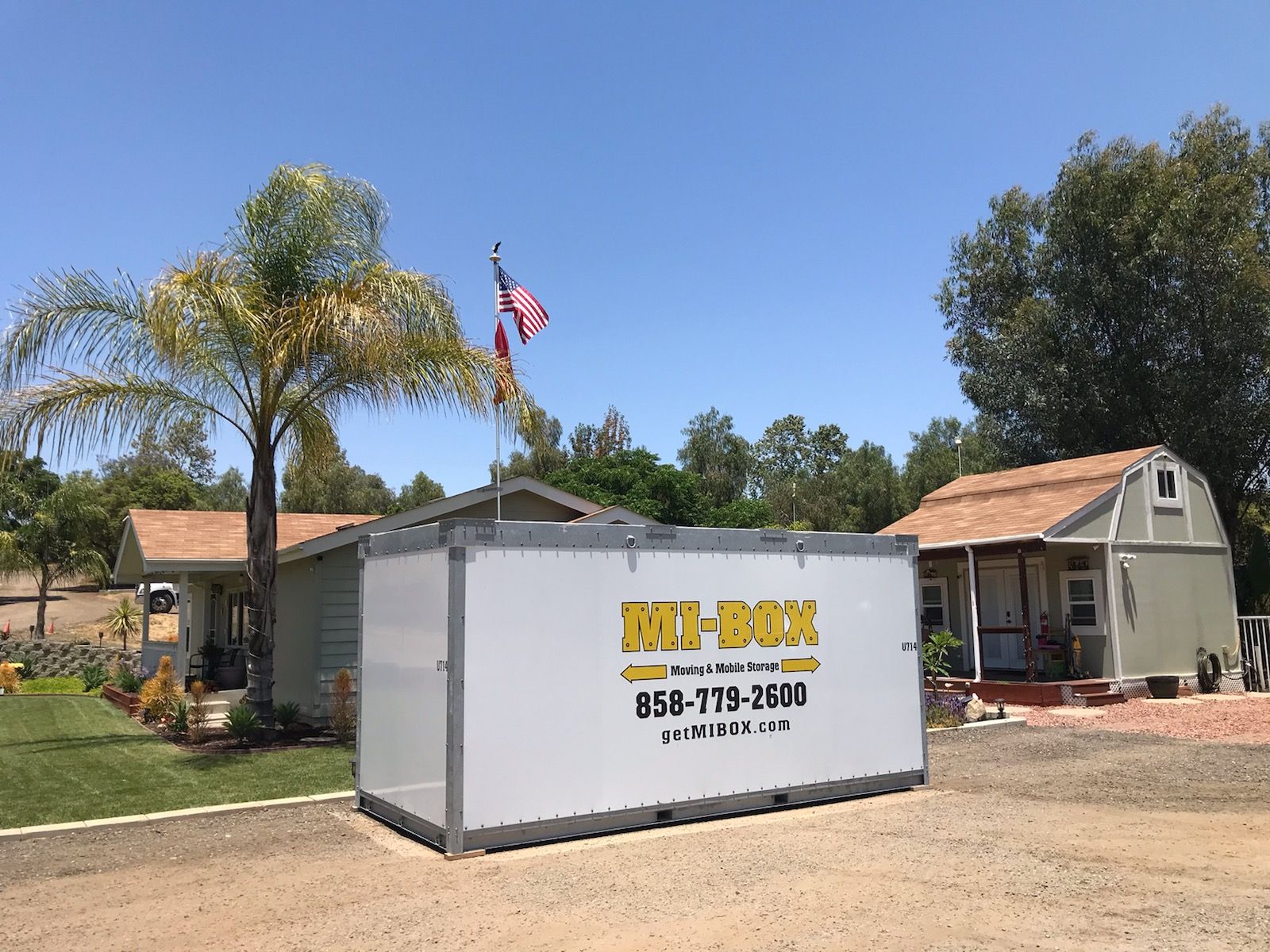 A white box is sitting in front of a house.