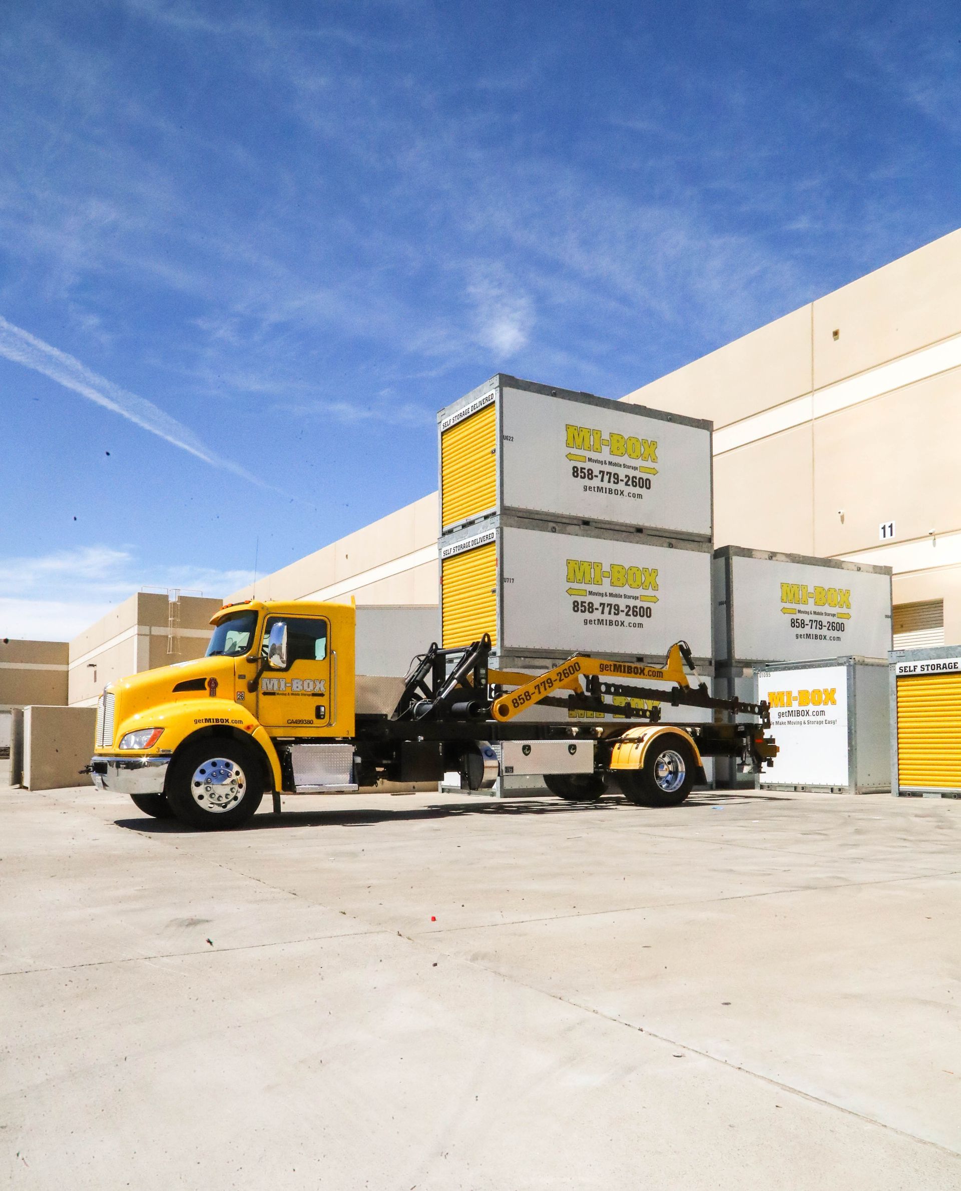 A yellow truck is parked in front of a building