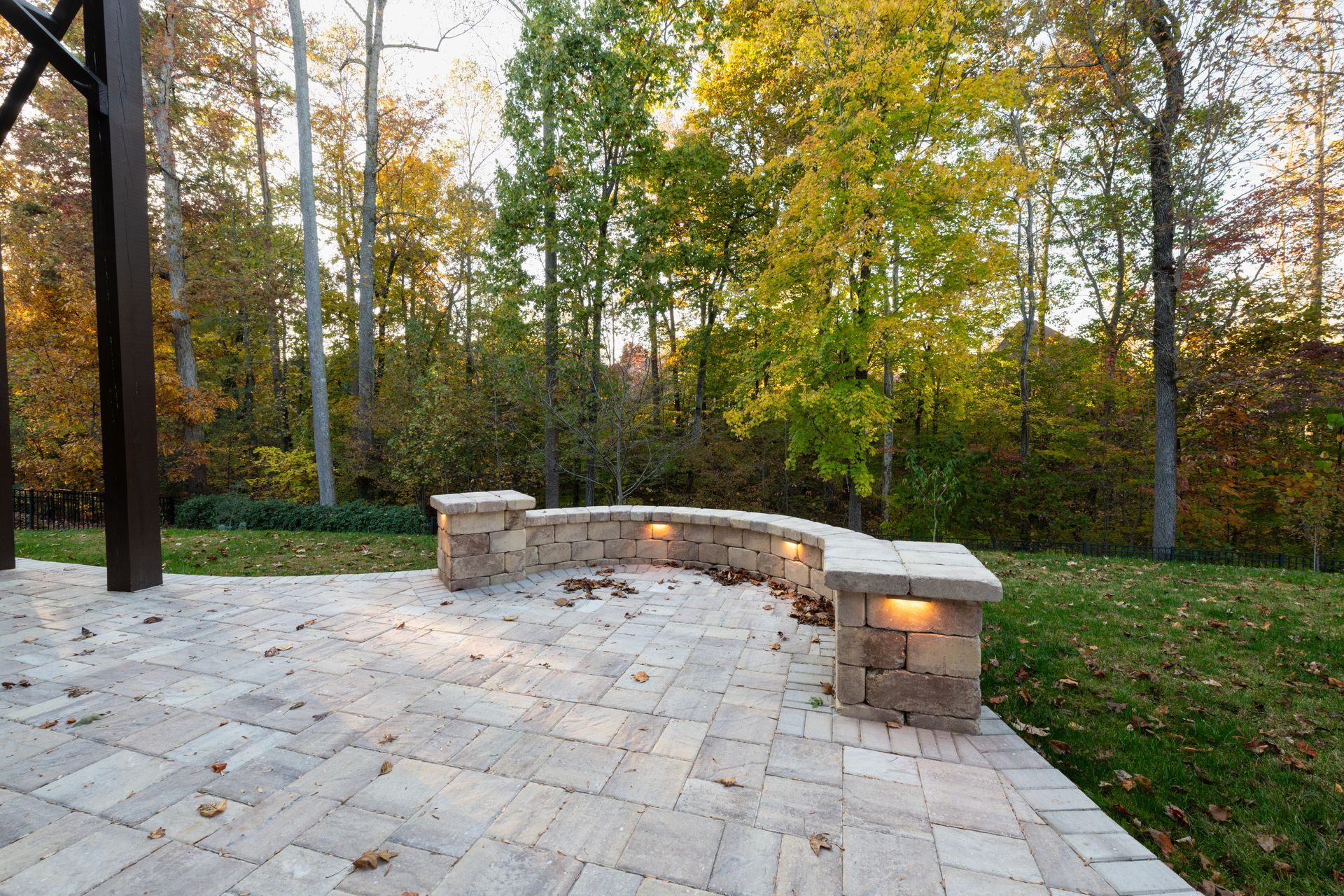 Un patio avec un banc et des arbres en arrière-plan.