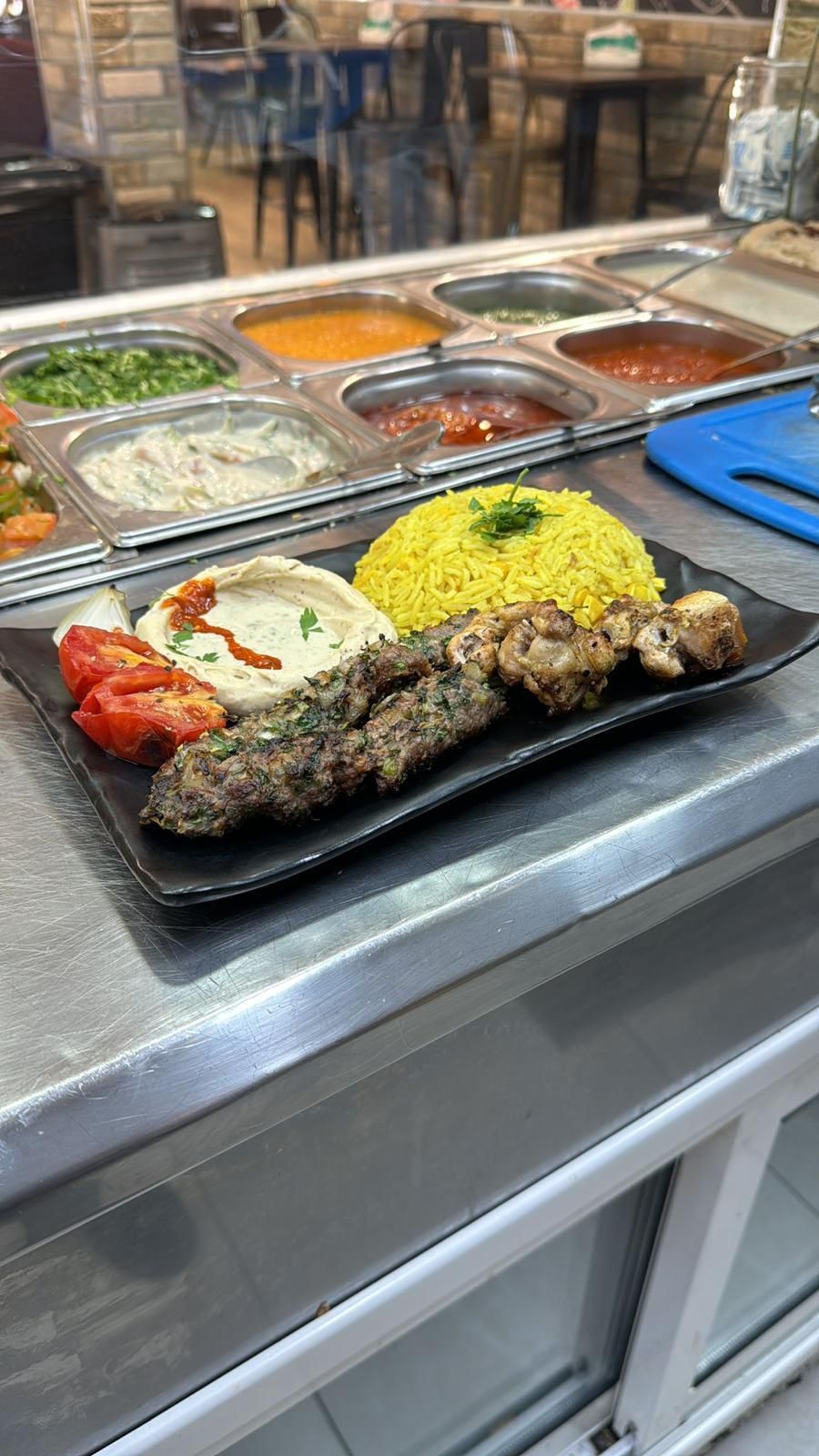 מגש הגשה של מגוון בשרים צלויים ואורז בדלפק בקפיטריה