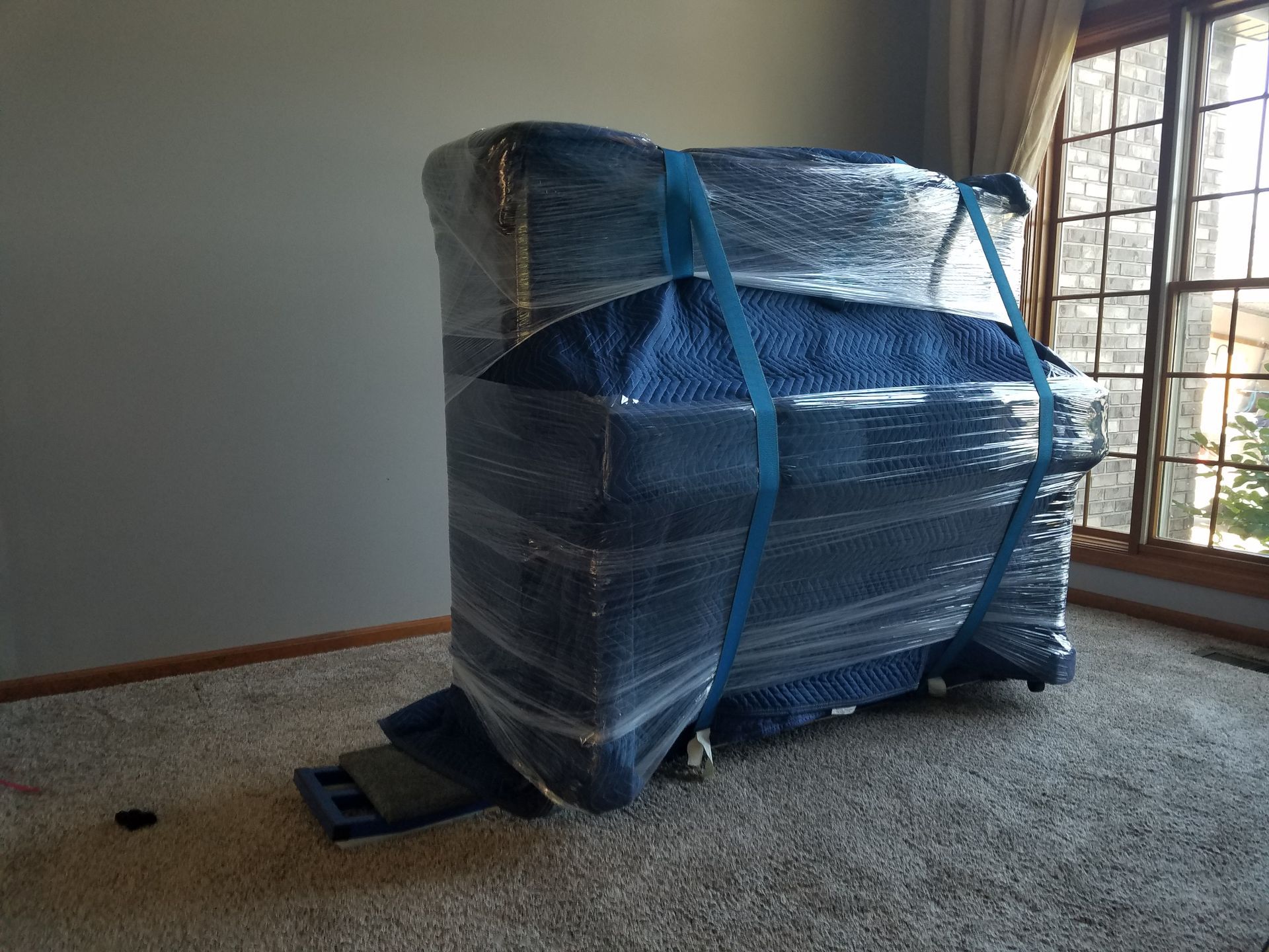 a piano is wrapped in plastic in a living room