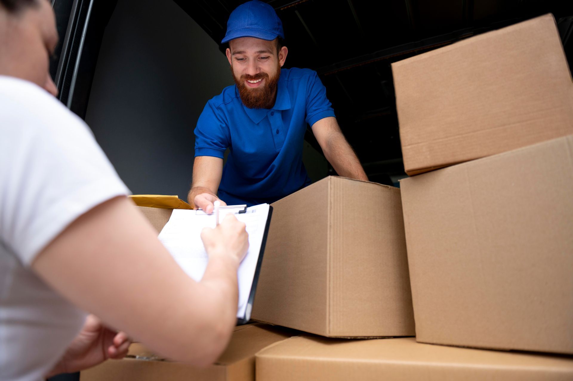 a man in a blue shirt is delivering a box to a woman