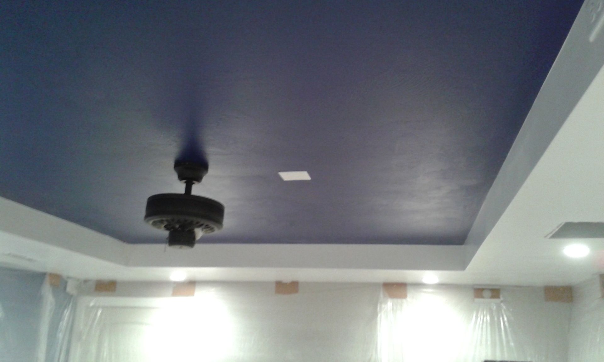 Blue painted ceiling with white trim, fan, and lights.