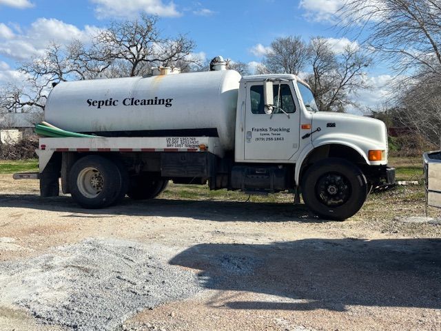 White septic cleaning truck parked on gravel, text 