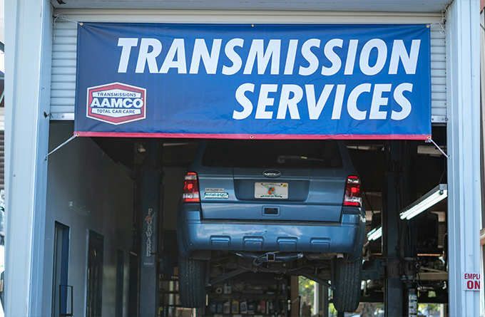 Blue car lifted in an auto shop under a 