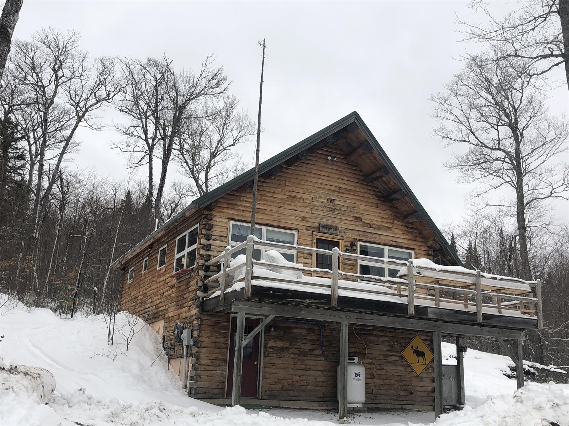 Snowy cabin with a wooden deck in a winter forest