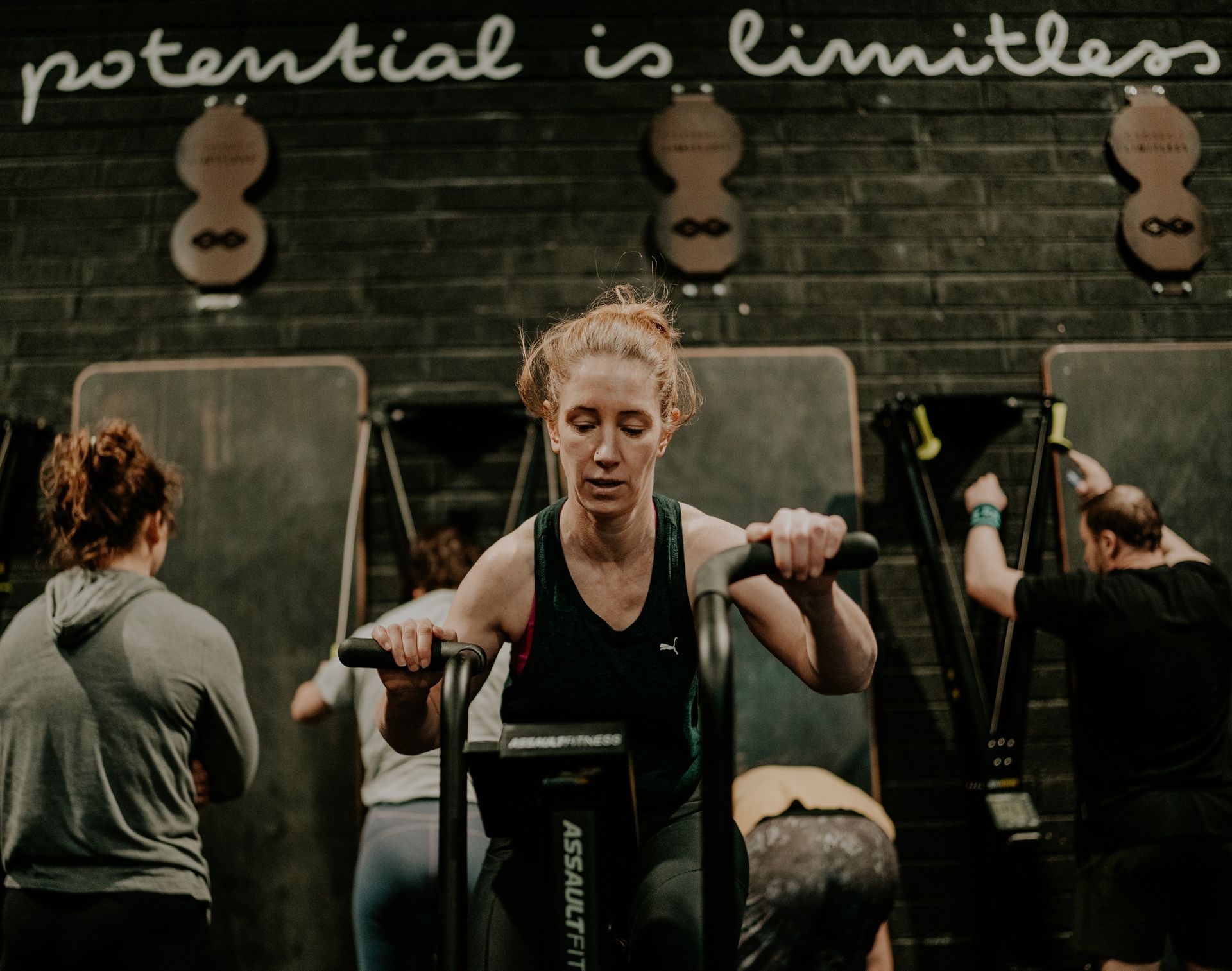 A shirtless man is sitting on a concept 2 rowing machine