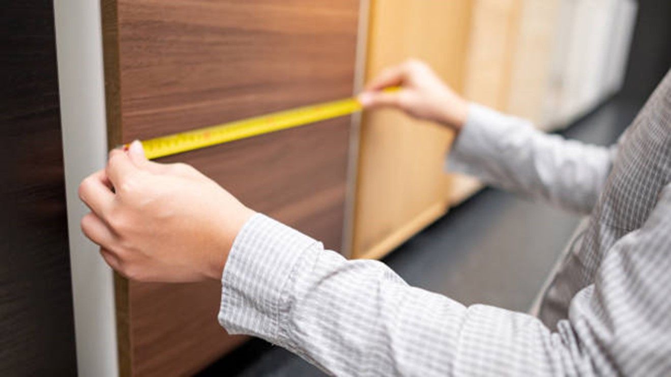 A person measuring a wood surface