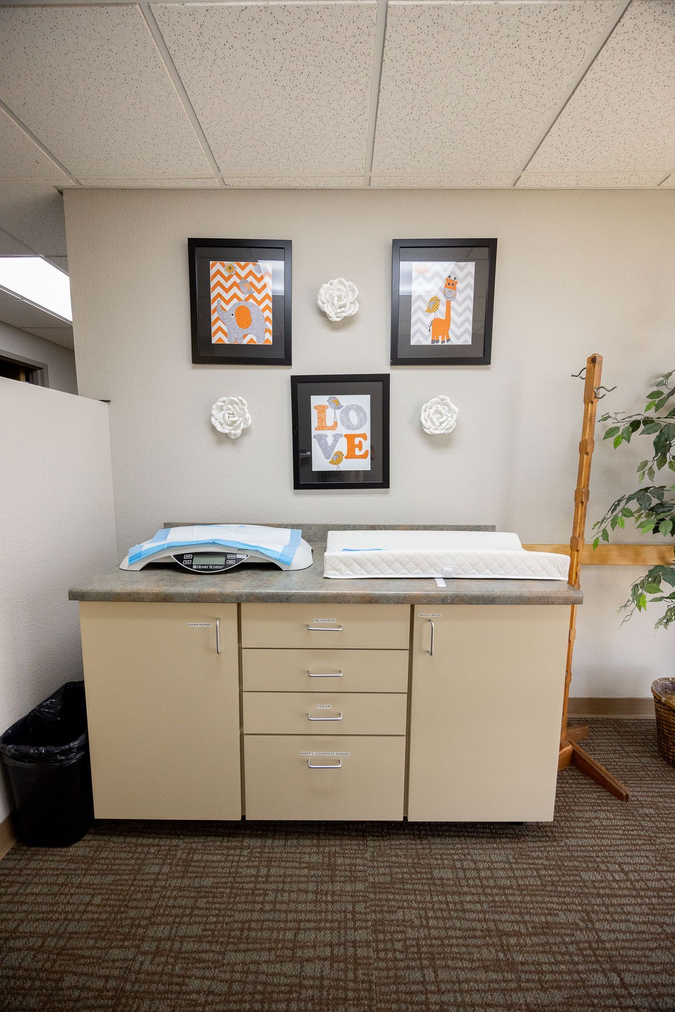 Office cabinet with framed art and paper stacks against a beige wall