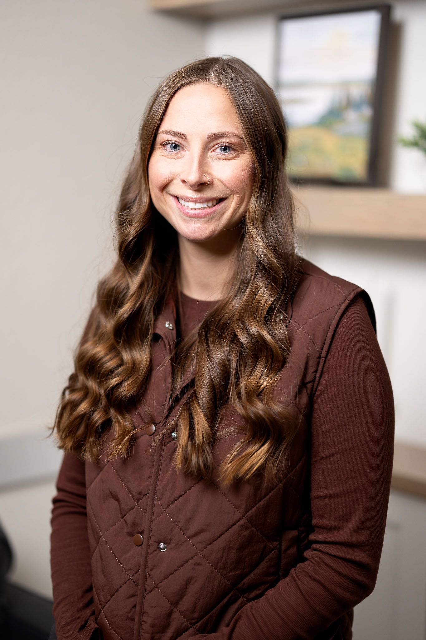 Natasha Agate, FNP in a maroon sweater standing indoors against a blurred office background