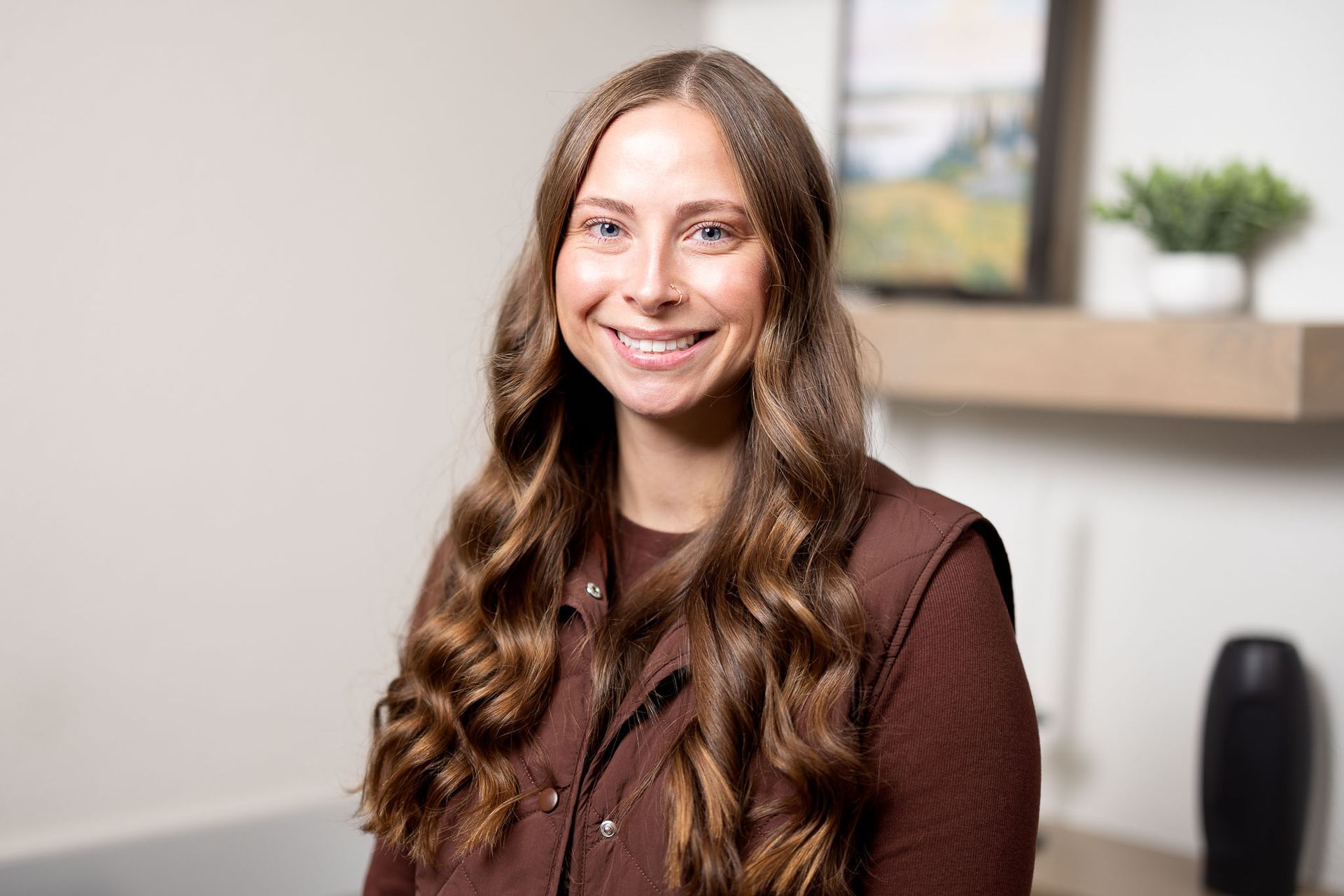 Natasha Agate, FNP smiling in a brown sweater, seated indoors against a softly lit office background.