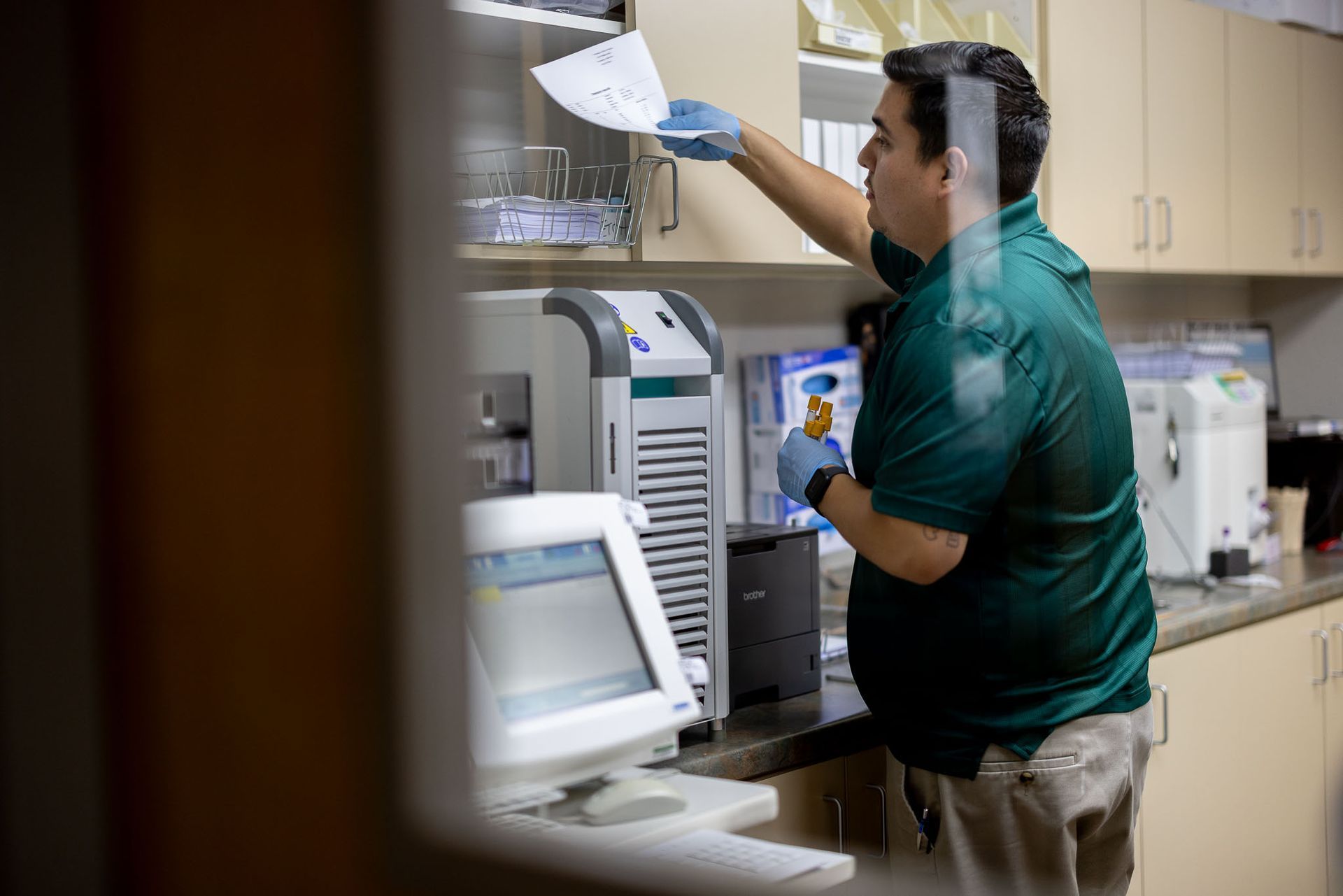 Man in green shirt around medical equipment in a medical lab