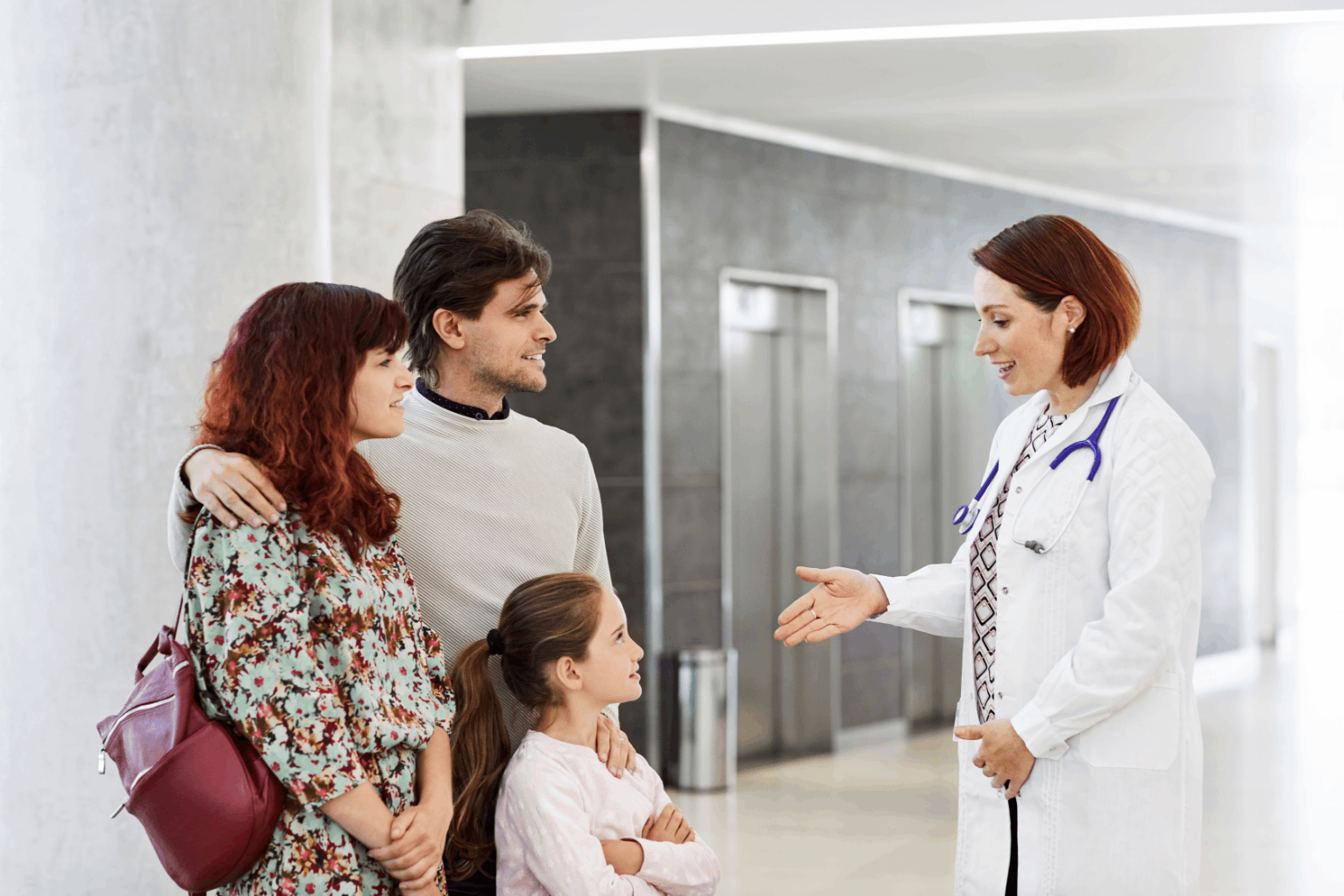 Doctor speaking with a family in a hospital hallway