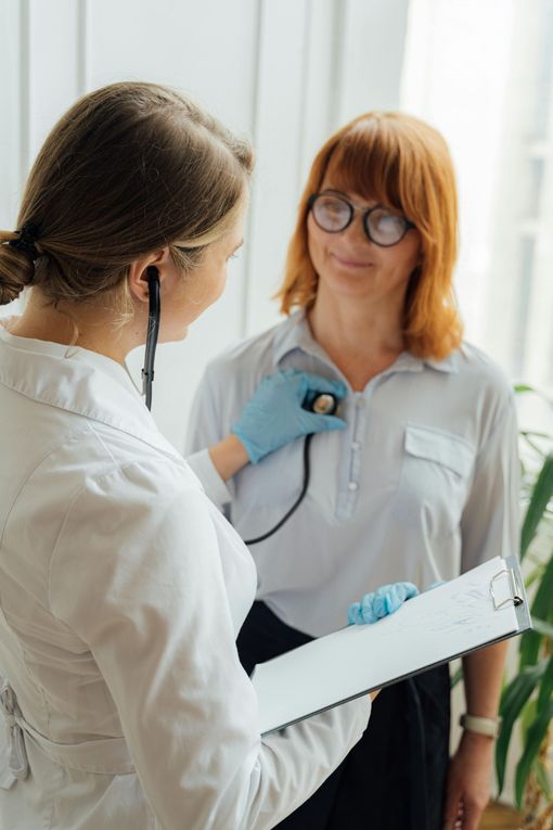 Doctor examining a patient with a stethoscope in a bright clinic room