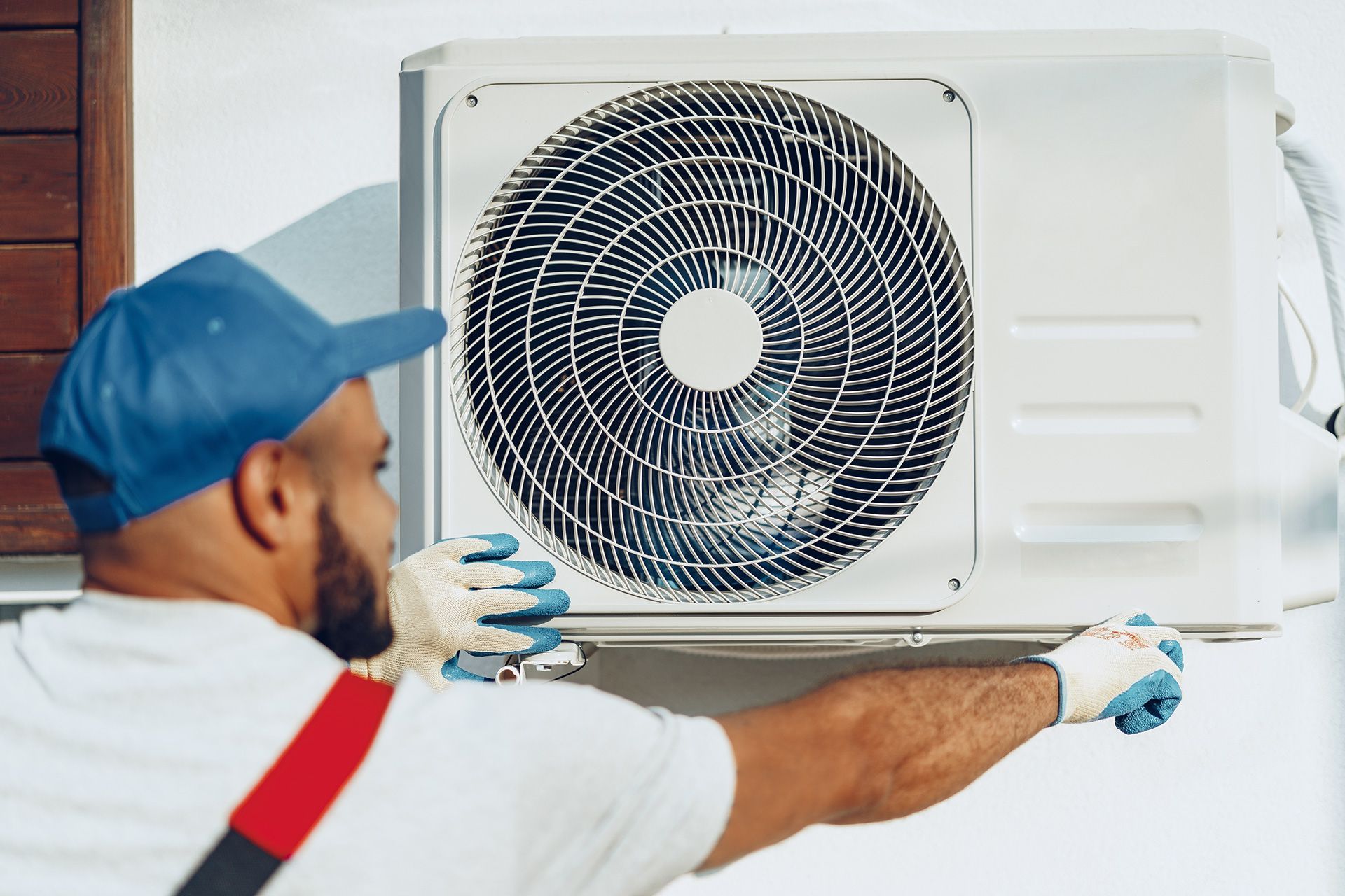 AC repair technician inspecting a Wellington home air conditioner