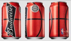 Três latas de cerveja Budweiser com um desenho de uma bola de basquete: vermelha com linhas pretas e um logotipo da NBA.