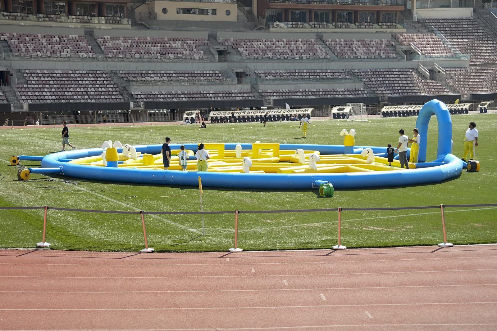 Estrutura inflável montada no gramado de um estádio durante um evento Confra FC