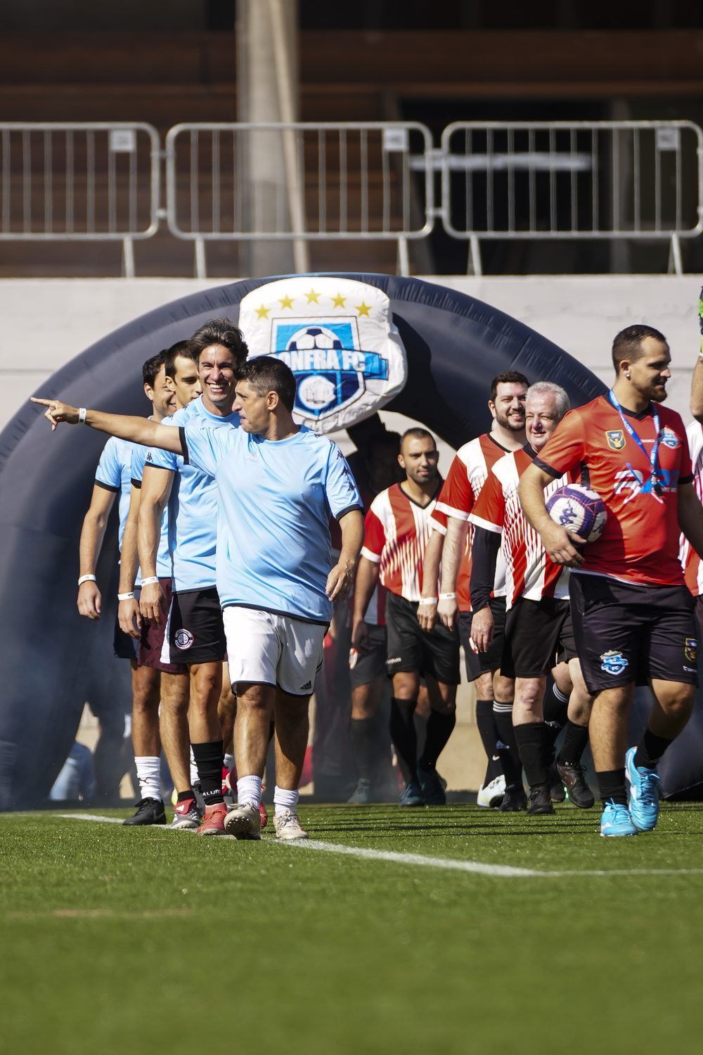 Times entrando em campo pelo túnel inflável com o escudo do Confra FC