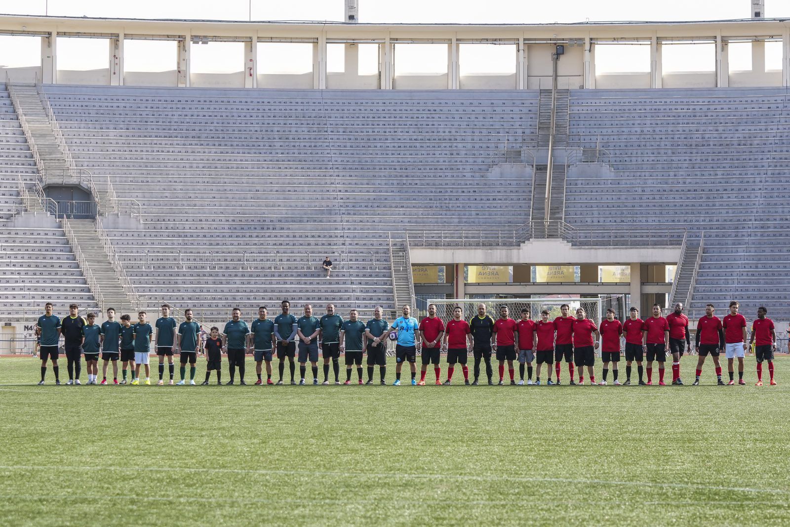 Times perfilados no gramado do estádio antes do início de uma partida do Confra FC