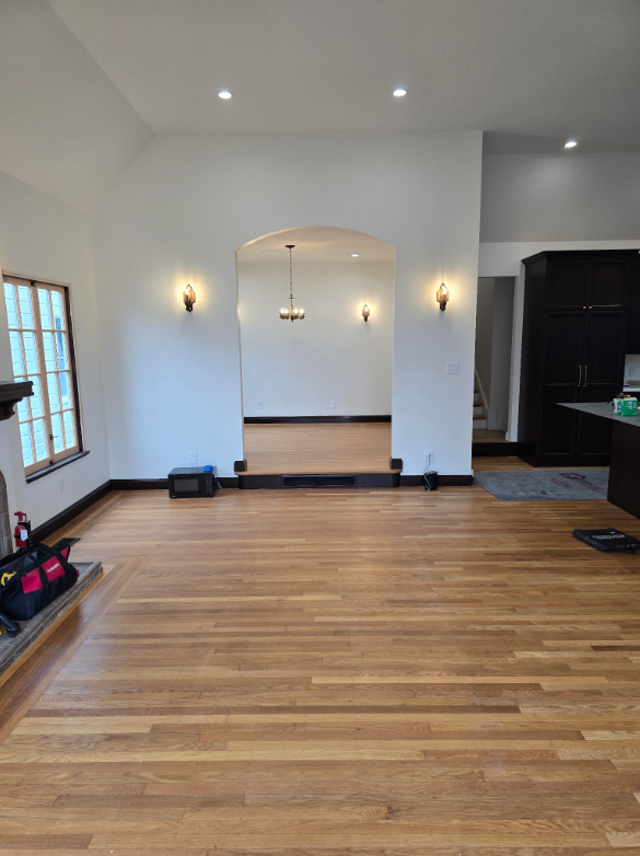 Empty room with hardwood floors, white walls, recessed lights, and a small recessed alcove.