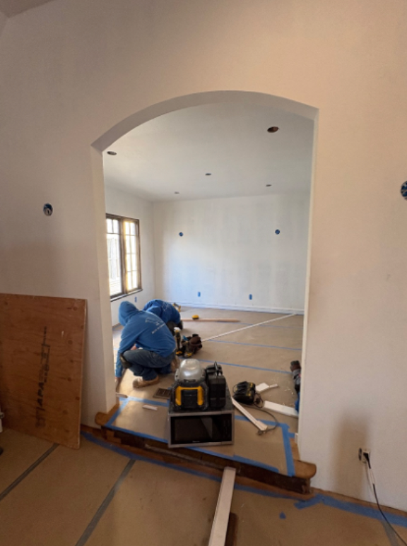 Renovation work in an arched doorway, with tools and materials on a room floor