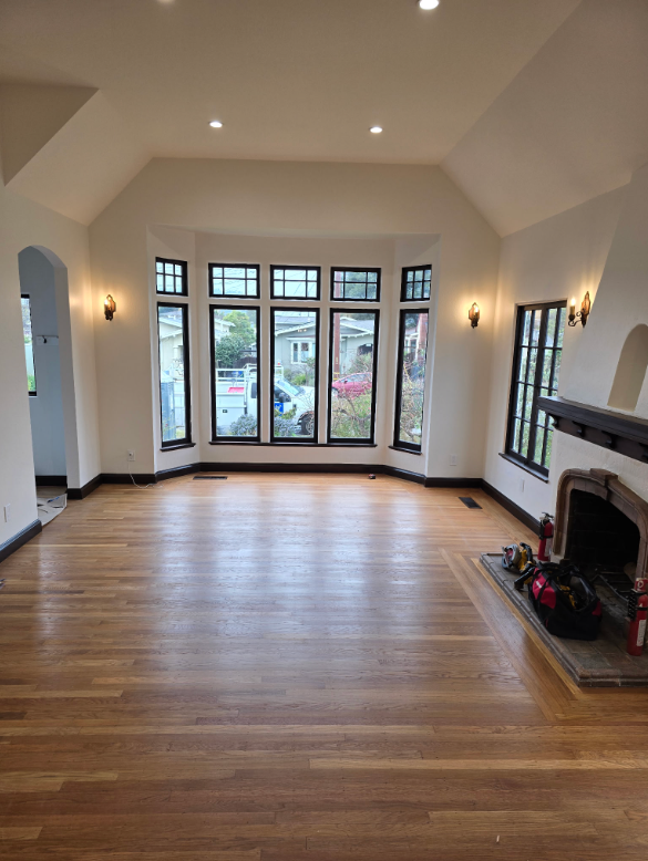 Empty living room with hardwood floors, high ceilings, and large French doors opening to a porch