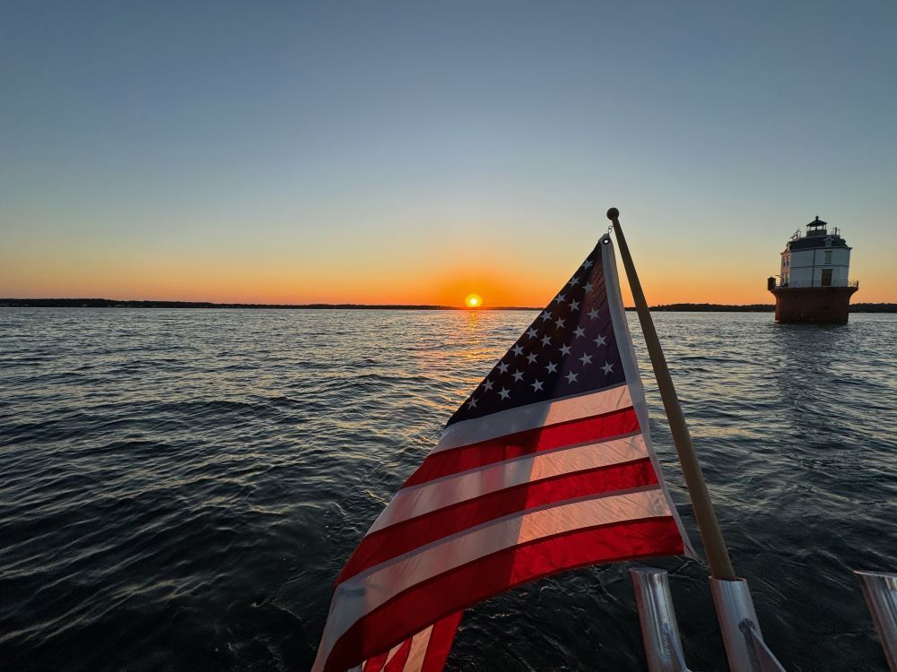 American flag flying in front of the lighthouse