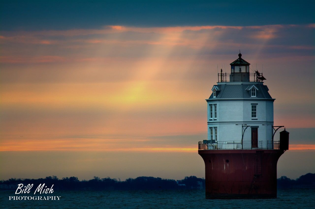 photo of Baltimore Lighthouse with sunlight streaming through clouds 