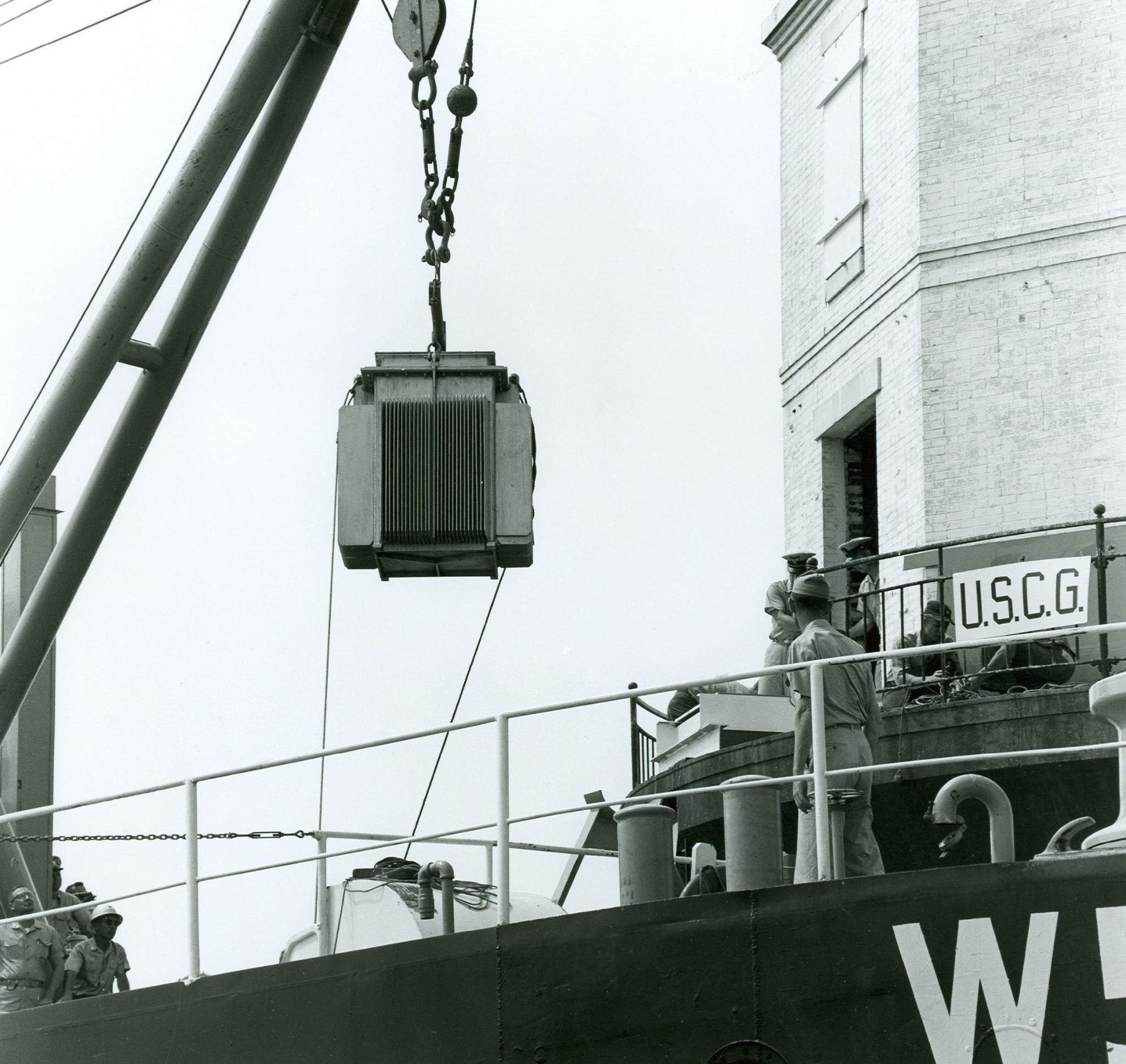 Image of the atomic fuel cell being loaded onto the lighthouse for powering the light in 1964