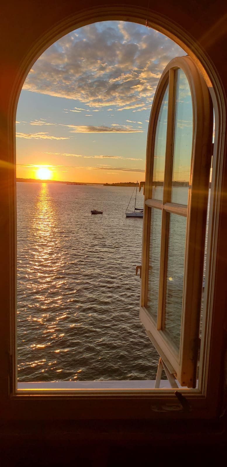 window open looking outside at the bay at sunrise