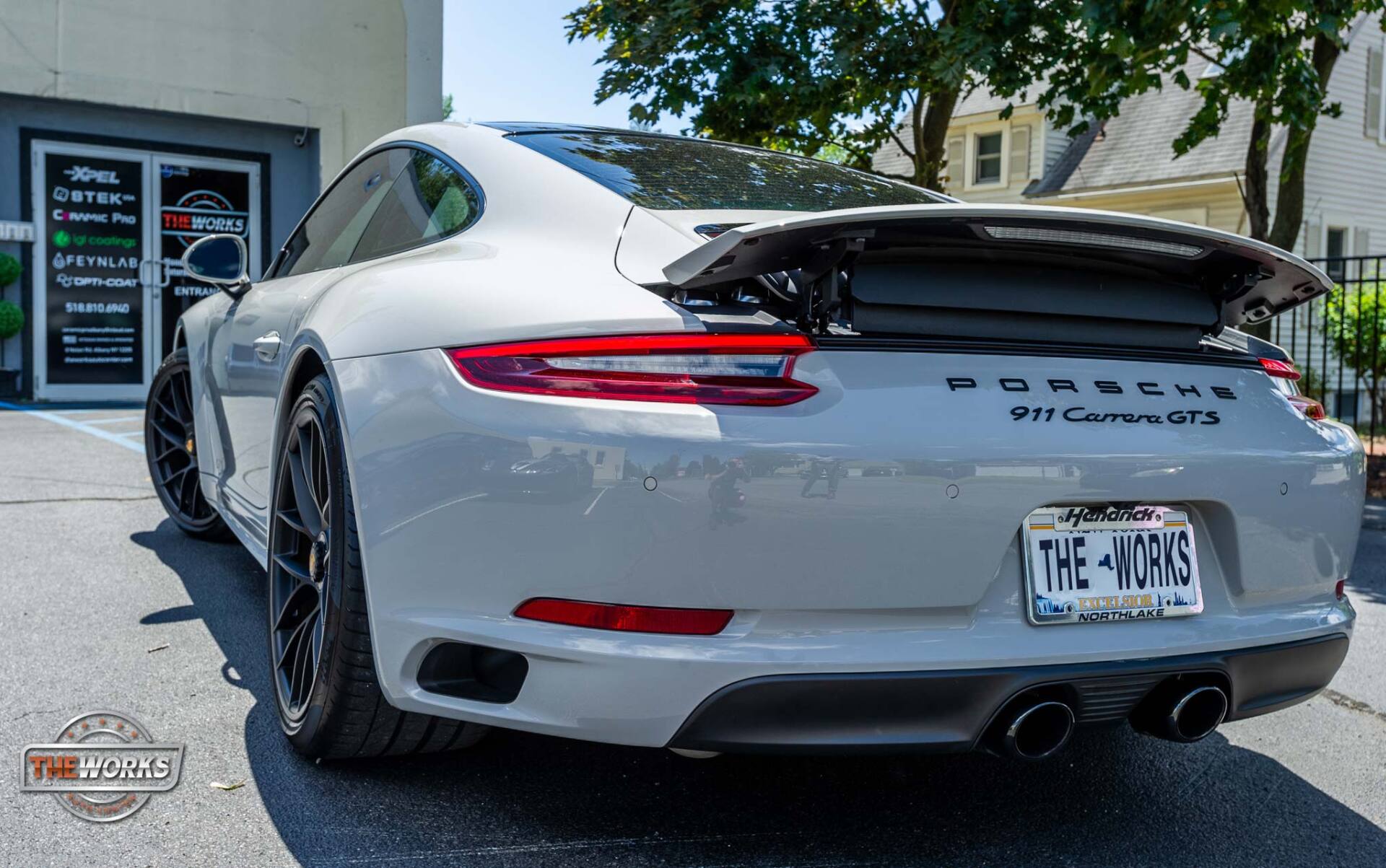 A white porsche 911 gt3 is parked in a parking lot.