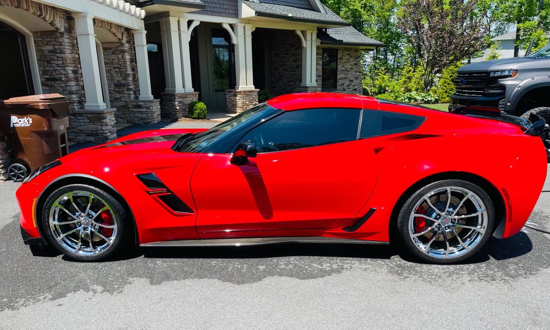 A red sports car is parked in front of a house