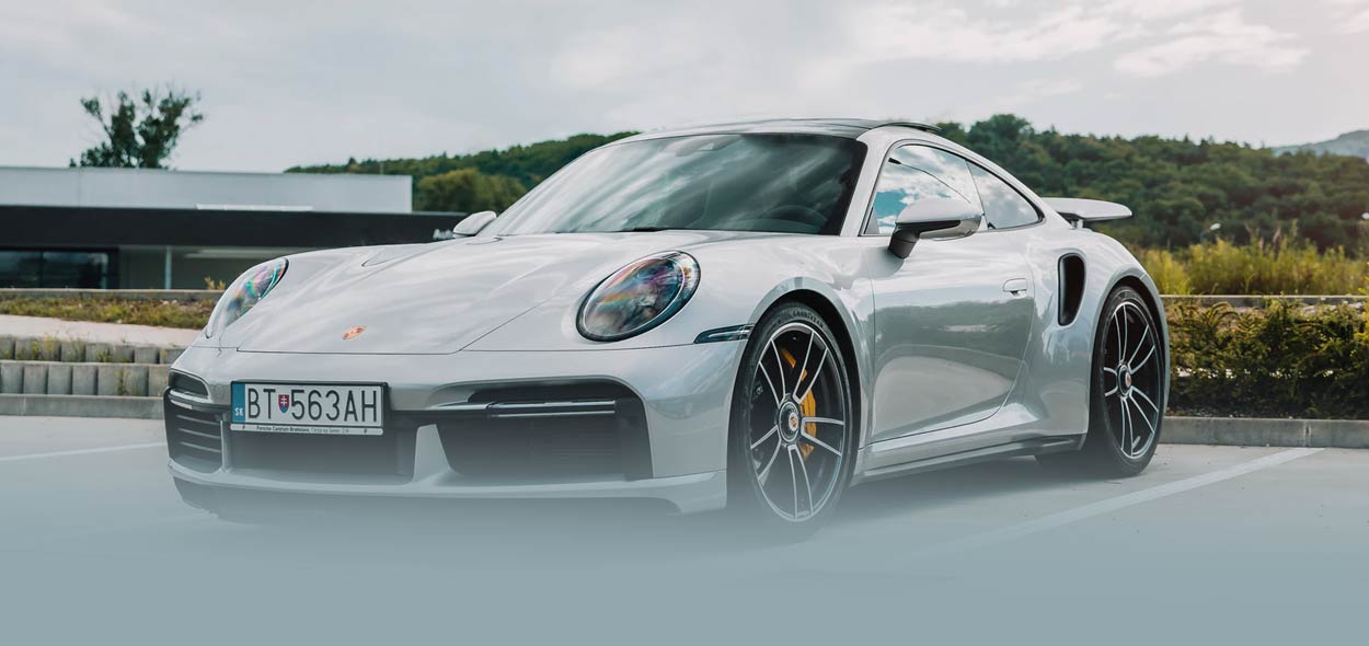 Silver Porsche 911 Turbo parked in a parking lot. Blue plate number reads BT 9004A.